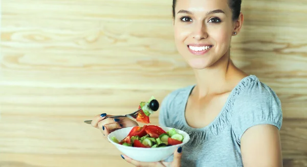 Vacker flicka äter hälsosam mat på trä bakgrund — Stockfoto