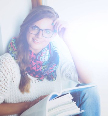 Yığın kitap ile oturan mutlu öğrenci kız