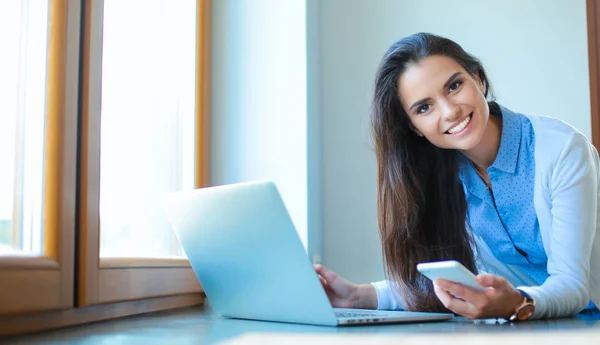 Młoda kobieta stojącego obok biurka z laptopa — Zdjęcie stockowe