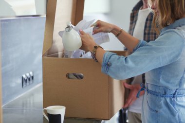 Genç bir çift yeni evde büyük karton kutu taşıyan. Ev taşıma. Genç Çift