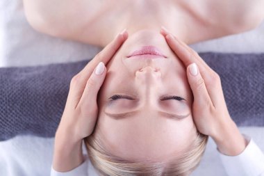 Masaj masasında uzanmış gözleri kapalı rahatlayan genç bir kadın. - Kadın. Spa salonu