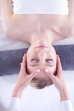 Masaj masasında uzanmış gözleri kapalı rahatlayan genç bir kadın. - Kadın. Spa salonu