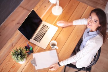 Masasında oturan ve elinde bir fincan kahveyle rahatlamış genç bir kadının portresi. İş kadını. İşyeri