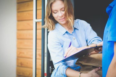 Mavi üniformalı gülümseyen kurye servis konseptine paket kutusu teslim eden teslimatçı. Mavi üniformalı gülümseyen teslimatçı.