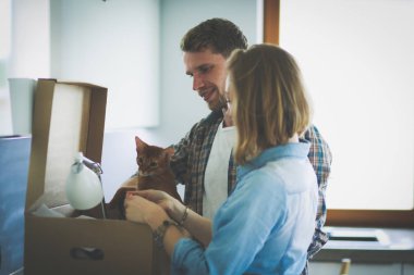 Genç bir çift yeni evde büyük karton kutu taşıyan. Ev taşıma. Genç Çift