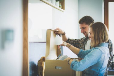 Genç bir çift yeni evde büyük karton kutu taşıyan. Ev taşıma. Genç Çift