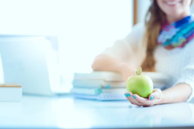 Bir yığın kitap üzerinde apple ile masaya oturan kadın üniversite öğrencileri. Öğrenci. Üniversite