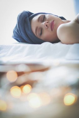 Masaj masasında uzanmış gözleri kapalı rahatlayan genç bir kadın. - Kadın. Spa salonu