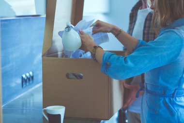 Genç bir çift yeni evde büyük karton kutu taşıyan. Ev taşıma. Genç Çift