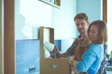 Genç bir çift yeni evde büyük karton kutu taşıyan. Ev taşıma. Genç Çift