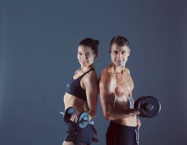 Atletik erkek ve kadın ile bir dumbells. Kişisel fitness eğitmeni. Kişisel eğitim.