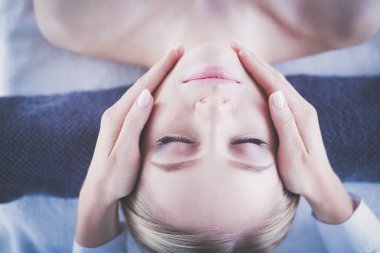 Masaj masasında uzanmış gözleri kapalı rahatlayan genç bir kadın. - Kadın. Spa salonu