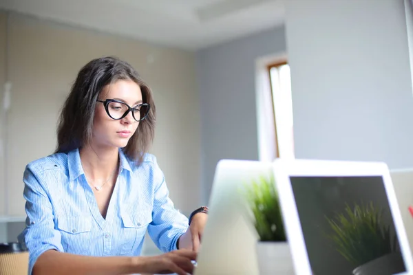 Młoda kobieta siedząca przy biurku, patrząca na ekran laptopa. Młoda kobieta — Zdjęcie stockowe