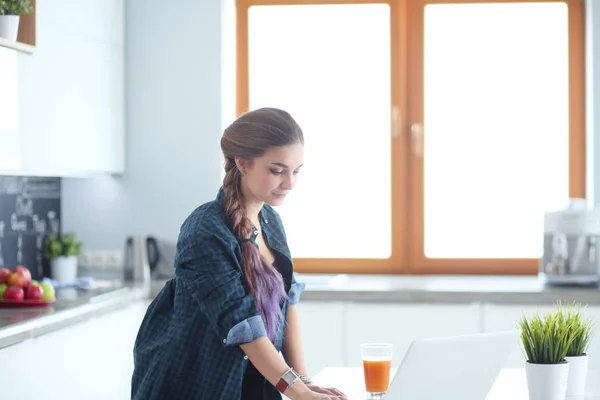 Mooie jonge glimlachende vrouwelijke arts zitten aan het bureau en schrijven. — Stockfoto