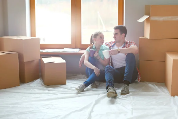 Par som flyttar i huset sitter på golvet. Par — Stockfoto