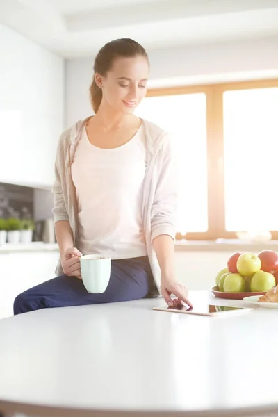 Lycklig kvinna dricka te i köket hemma. — Stockfoto