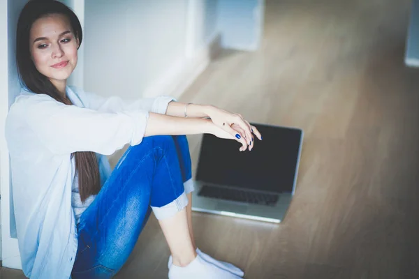 Mooie jongedame thuis zittend op de vloer met laptop. Mooie jongedame. — Stockfoto