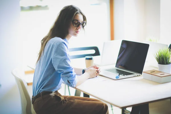 Jovem sentada à mesa do escritório com laptop. Jovem. Laptop — Fotografia de Stock