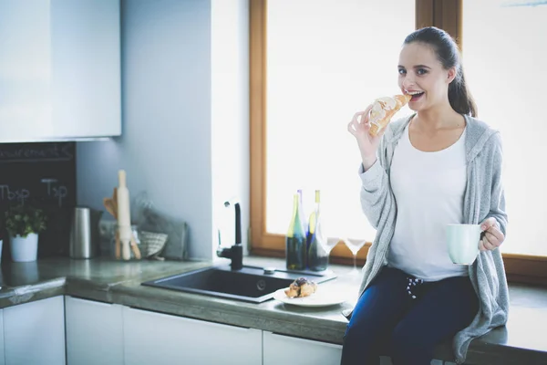 Schöne junge Frau mit einem digitalen Tablet in der Küche. — Stockfoto