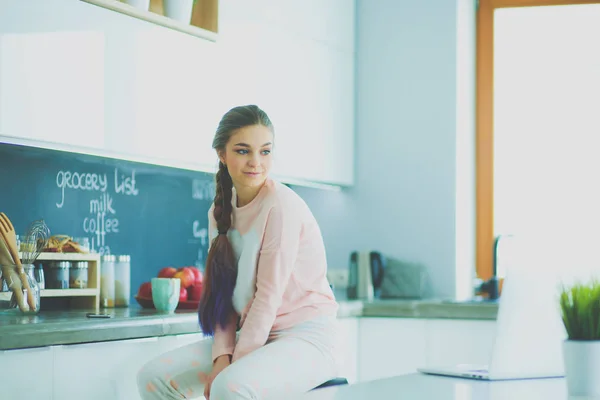 Mujer joven sentada en la mesa en la cocina . —  Fotos de Stock