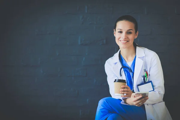 Young woman doctor sitting with your phone. Woman doctors. — Stock Photo, Image