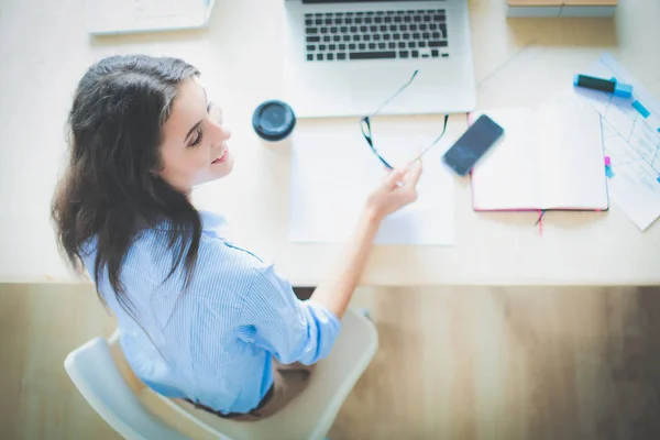 Mladá žena sedí v kanceláři a dívá se na monitor notebooku. Mladá žena — Stock fotografie