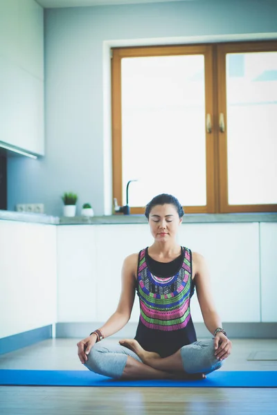 Mujer joven haciendo yoga en casa en la posición de loto. Yoga. Una mujer. Estilo de vida — Foto de Stock