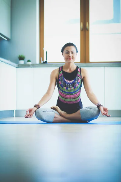 Mujer joven haciendo yoga en casa en la posición de loto. Yoga. Una mujer. Estilo de vida — Foto de Stock