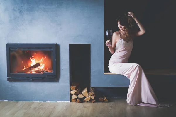 Sexy Frau vor dem Kamin. Holzkamin. — Stockfoto