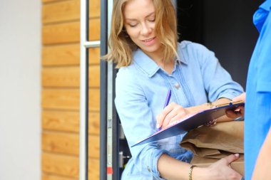 Mavi üniformalı gülümseyen kurye servis konseptine paket kutusu teslim eden teslimatçı. Mavi üniformalı gülümseyen teslimatçı.