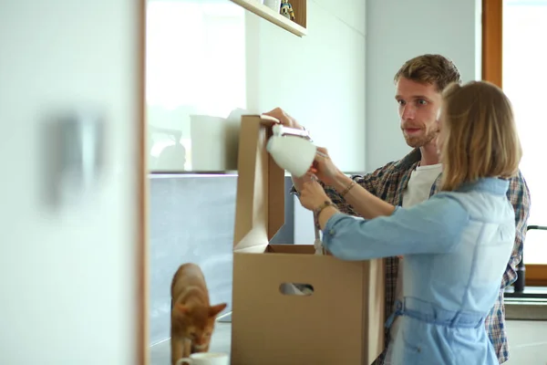 Jong koppel uitvoering van grote kartonnen doos nieuwe thuis. Verhuizing. Jong koppel — Stockfoto