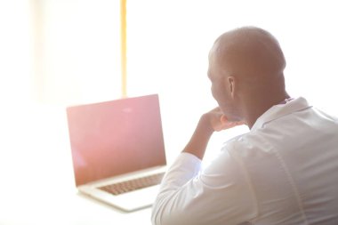 Masada dizüstü bilgisayarla çalışan genç bir Afrikalı doktor. Doktor bey. İşyeri