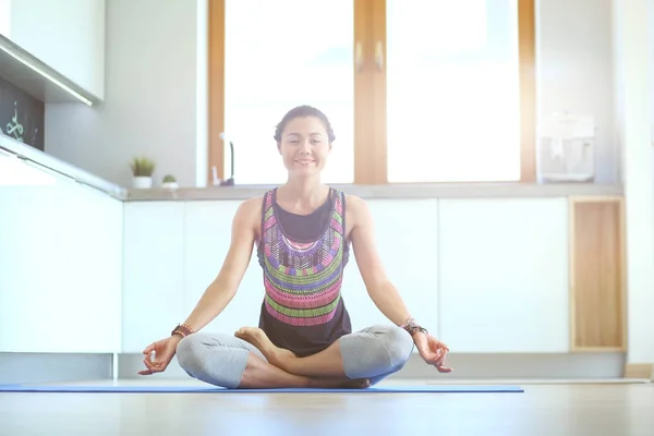 Mujer joven haciendo yoga en casa en la posición de loto. Yoga. Una mujer. Estilo de vida — Foto de Stock