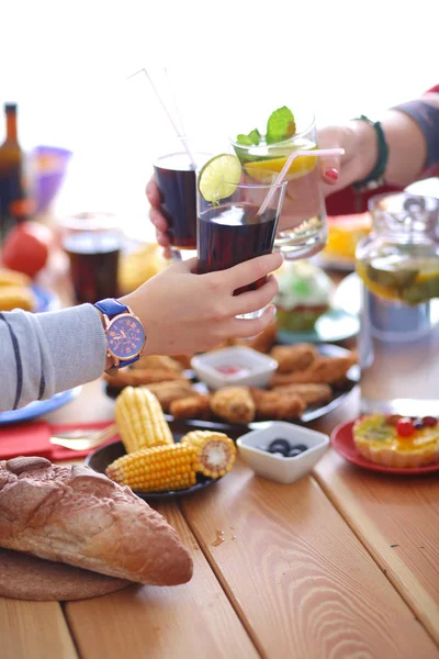 Vue du dessus du groupe de personnes qui dînent ensemble tout en étant assis à une table en bois. De la nourriture sur la table. Les gens mangent fast food. — Photo