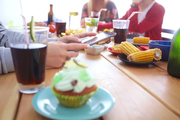 Draufsicht auf eine Gruppe von Menschen beim gemeinsamen Abendessen, während sie am Holztisch sitzen. Essen auf dem Tisch. Menschen essen Fast Food. — Stockfoto