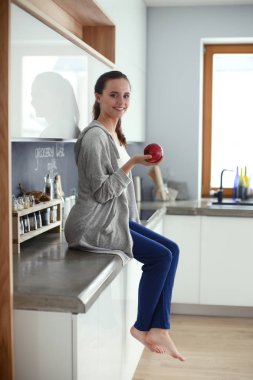 modern mutfakta otururken cep telefonu kullanan kadın.