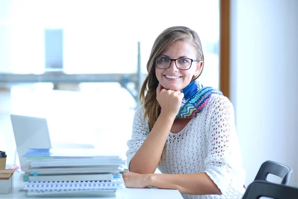 Młoda kobieta siedząca za biurkiem wśród książek. Student — Zdjęcie stockowe