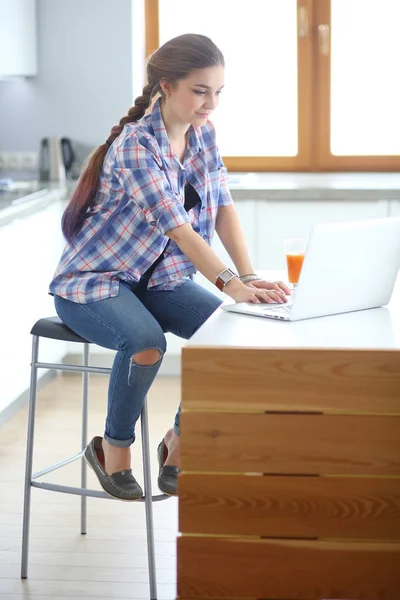 Schöne junge lächelnde Ärztin sitzt am Schreibtisch und schreibt. — Stockfoto