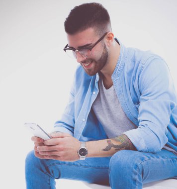 Sandalyede oturan ve cep telefonuyla genç adam. Startupper. Y