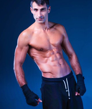 Siyah arka plan üzerine ayakta güçlü atletik adam