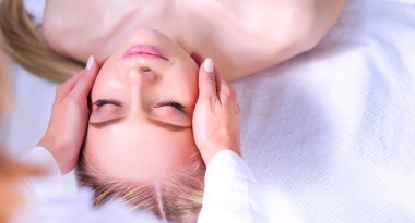 Gözleri kapalı rahatlatıcı bir masaj masanın üzerinde yatan genç kadın