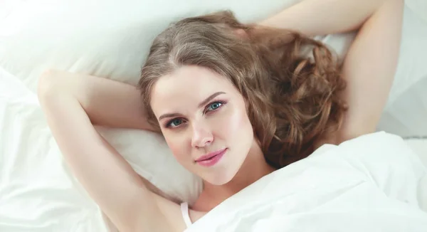 Vacker kvinna som ligger på sin säng hemma — Stockfoto