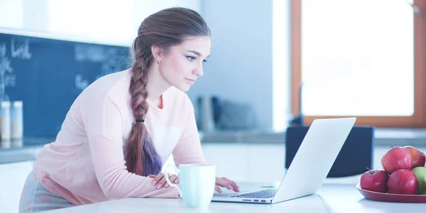 Junge Frau sitzt mit Laptop am Küchentisch und redet — Stockfoto