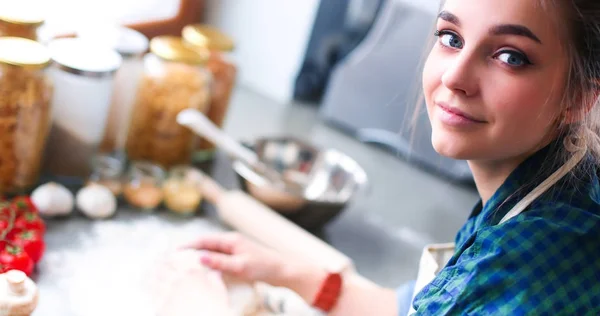 Vacker kvinna matlagning tårta i köket står nära skrivbordet — Stockfoto
