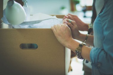 Genç bir çift yeni evde büyük karton kutu taşıyan. Ev taşıma. Genç Çift