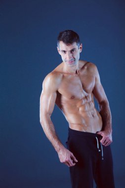 kaslı adam. Kaslı adam kas gösterilen gri arka plan üzerinde. Fitness Eğitmeni. Fitness profesyonel. Egzersiz. Mens fitness.