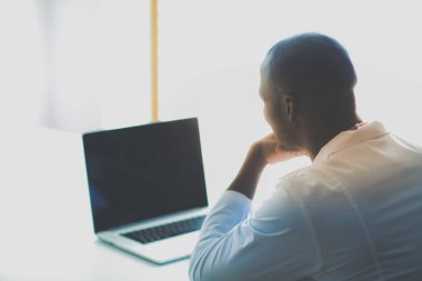 Masada dizüstü bilgisayarla çalışan genç bir Afrikalı doktor. Doktor bey. İşyeri