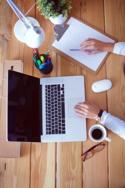 Masada oturan genç bir kadın..