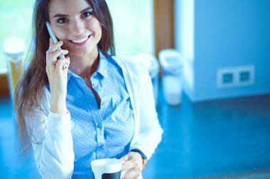 evde Mutfakta çay içme ve telefonda konuşurken mutlu kadın. Kadın mutfakta.