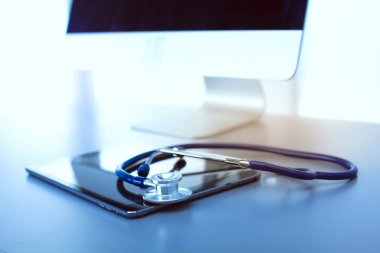 Tıbbi ekipman: Beyaz arka planda mavi steteskop ve tablet. Tıbbi ekipman